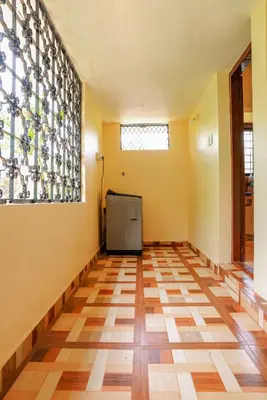 a room with yellow walls and a checkered floor at Orange Villa -3 AC Rooms Near Airport in Ernakulam