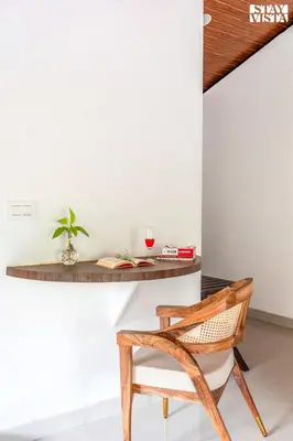 a desk and a chair in front of a room at StayVista at Hermitage 4BR - Boutique Stay - Relax in Nature in Irpu