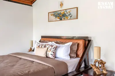 a bedroom with a large bed with pillows at StayVista at Hermitage 4BR - Boutique Stay - Relax in Nature in Irpu