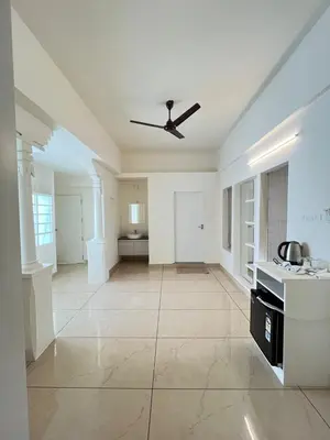 a large white kitchen with a ceiling fan at Aagneyam Grand Resort in Kozhikode