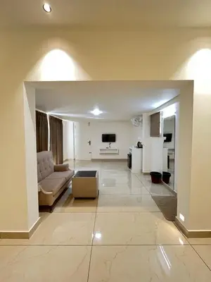a living room with a couch and a television at Aagneyam Grand Resort in Kozhikode