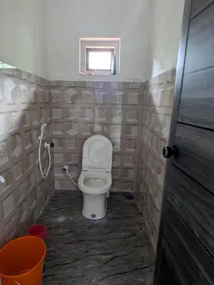 a bathroom with a toilet and a window at Silent Stays in Kelakam