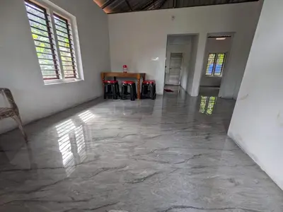 an empty room with a table and two windows at Silent Stays in Kelakam