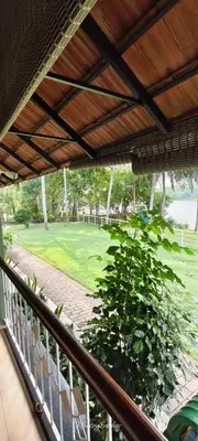 a balcony with a view of a green bush at BharathaPuzha Resort in Kārakkād