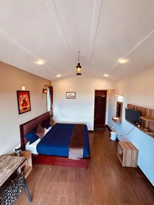 a bedroom with a bed and a television in it at Ever Fresh High View By Let's Inn in Ooty