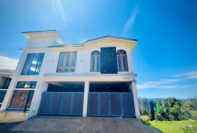 a large white house with a blue gate at Ever Fresh High View By Let's Inn in Ooty