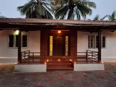 a house with a front porch with stairs and lights at Farm Retreat by TastyTek in Pollāchi