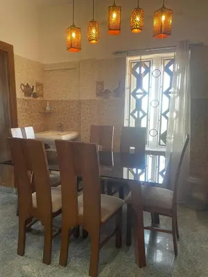 a dining room with a table and chairs and lights at IndivaStays - Moon Stone Villa in Ooty