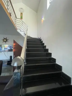 a staircase with black steps in a building at IndivaStays - Moon Stone Villa in Ooty