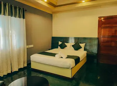 a bedroom with a white bed with black and white pillows at Upavan Villa-Two KM From Aluva Metro Station in Alwaye