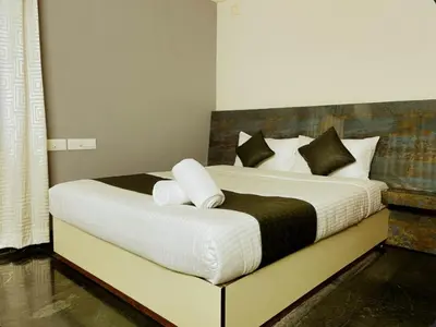 a bedroom with a large bed with black and white pillows at Upavan Villa-Two KM From Aluva Metro Station in Alwaye