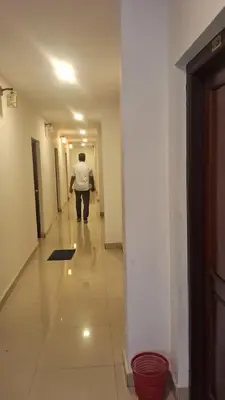 a man walking down a hallway in a building at Hill palace Inn in Periya