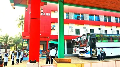 a bus is parked in front of a building at Hill palace Inn in Periya
