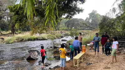 a group of people standing near a river at Coffee Courtyard - Boutique Estate Retreat, Coorg in Kurchi
