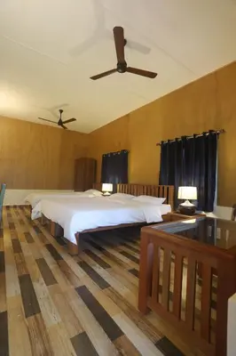 a bedroom with a large bed and a ceiling fan at Coffee Courtyard - Boutique Estate Retreat, Coorg in Kurchi