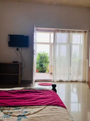 a bedroom with a bed and a tv and a window at Nvoyages Plantataion Stay Coorg in Madikeri