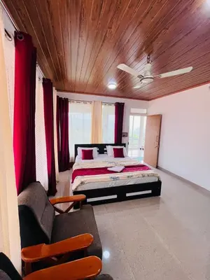 a bedroom with a bed and a wooden ceiling at Nvoyages Plantataion Stay Coorg in Madikeri