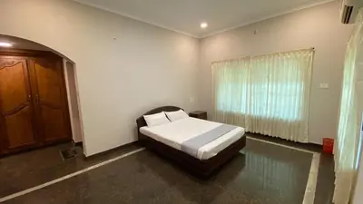 a bedroom with a bed and a window at Abida Mansion 4BHK Near MCP Convention Centre Irinjalakuda in Irinjālakuda
