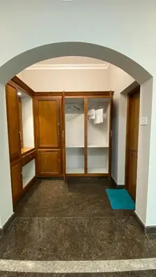 an archway in a room with wooden cabinets and towels at Abida Mansion 4BHK Near MCP Convention Centre Irinjalakuda in Irinjālakuda