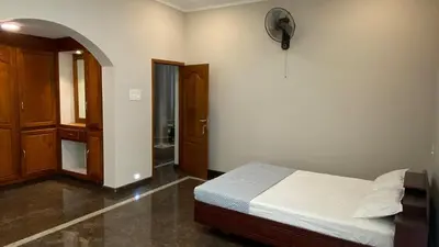 a bedroom with a bed and a clock on the wall at Abida Mansion 4BHK Near MCP Convention Centre Irinjalakuda in Irinjālakuda