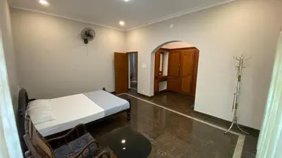 a bedroom with a bed and a table and chairs at Abida Mansion 4BHK Near MCP Convention Centre Irinjalakuda in Irinjālakuda