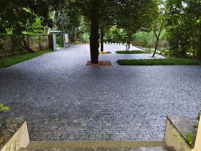 a cobblestone walkway with a tree in the middle at Aathira Agri Homes in Trichūr