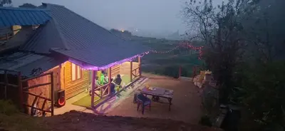 a house with a picnic table and purple lights on it at Mud bees resort in Kanthalloor