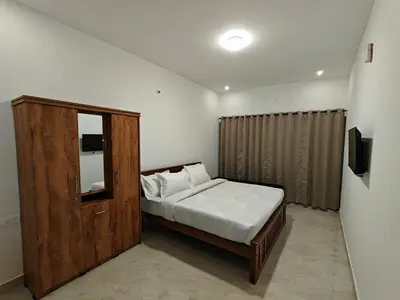 a small bedroom with a bed and a mirror at Mithra Cottages Individual Room's with Balcony in Ooty