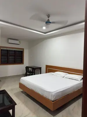 a bedroom with a bed with a ceiling at RV Tourist Home in Ponnāni