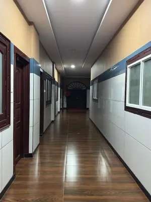 an empty hallway of a school with a door and wood floors at RV Tourist Home in Ponnāni