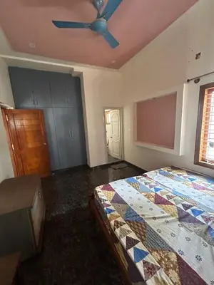 a bedroom with a bed and a ceiling fan at Aalaya in Mysore