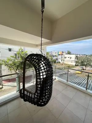 a hanging basket swing in a room with a window at Aalaya in Mysore