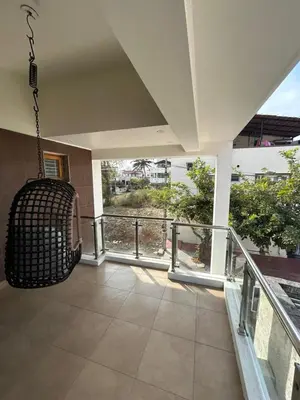 a porch with a swing on a balcony at Aalaya in Mysore
