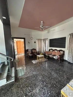 a large living room with couches and a table at Aalaya in Mysore