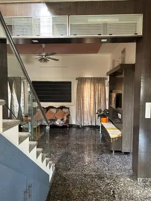 a living room with a ceiling fan and a couch at Aalaya in Mysore