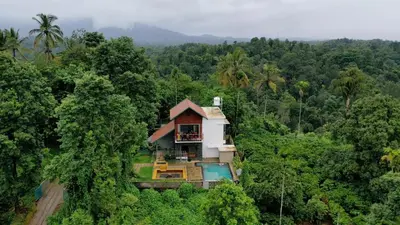 a house in the middle of the forest at Hill Brown Resort in Kalpetta