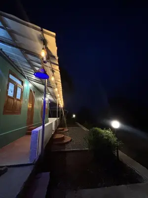 a building with lights on the side of it at night at ViAN Mistyrocks in Mamalakandam