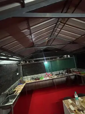 a kitchen with a long counter with a red floor at ViAN Mistyrocks in Mamalakandam