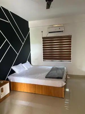 a bedroom with a bed with a black and white wall at Highland Residency in Attappādi
