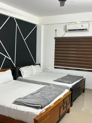 two twin beds in a room with at Highland Residency in Attappādi