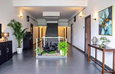 a hallway with plants and a staircase in a building at Highland Residency in Attappādi