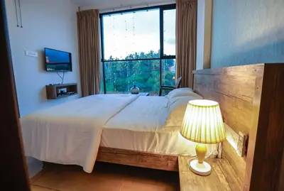 a bedroom with a large bed with a large window at Atholi Residency in Mukkam