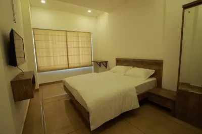 a small bedroom with a bed and a window at Atholi Residency in Mukkam
