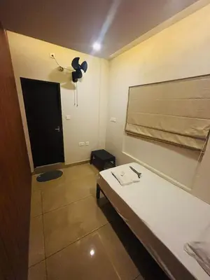 a room with a bed and a door with a fan at Atholi Residency in Mukkam