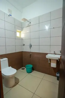 a bathroom with a toilet and a sink at Atholi Residency in Mukkam