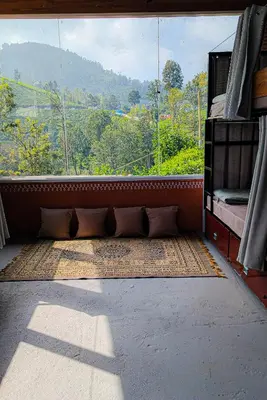 a room with a window with a view of a mountain at Mad & Nomad Backpackers Hostel in Coonoor