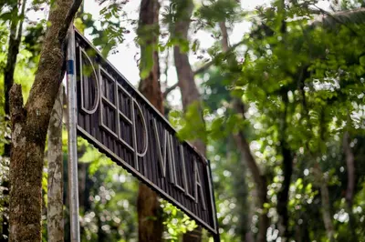 a black street sign in front of a tree at DEEP ViLLA in Batheri