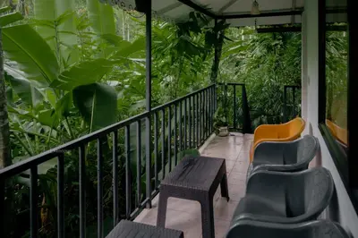 a balcony with chairs and a table and some plants at DEEP ViLLA in Batheri
