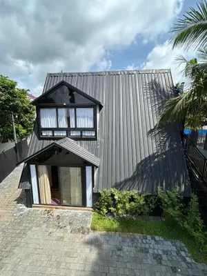 a small house with a black roof at Mangalath River View Resorts in Kodanad