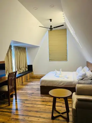 a room with a bed and a couch and a table at Mangalath River View Resorts in Kodanad